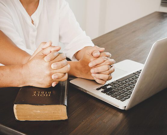Two people discussing a project with notebooks and a laptop on a table, symbolizing strategic planning and the collaborative solution for digital marketing and SEO.